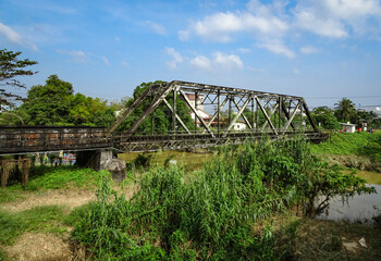 Vintage rusty old railway bridge over the river.