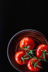 tomatoes on a plate on a black background