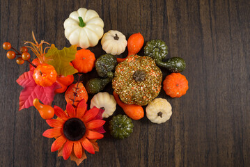 Group of small decorative pumpkins of different shapes on wooden table. Autumn background.