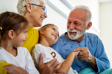 Fototapeta premium Happy grandchildren visiting grandfather at hospital ward. Support, family and healthcare concept.