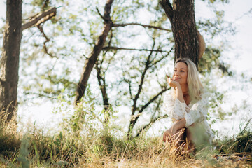 girl artist, woman paints picture landscape, summer forest, denim shorts, creating creativity artistic mood. Blank white canvas getting started. Grass trees background.