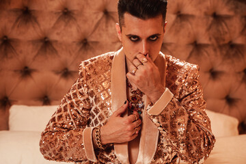 Rich and eccentric man dressed in a shimmering golden suit in a royal, luxurious suite