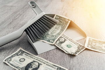 Dustpan and brush alongside scattered one-dollar bills on the floor