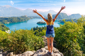 Travel destination in Slovenia- tour tourism on Bled lake,  woman tourist with open arms enjoying panoramic landscape view- Slovenia