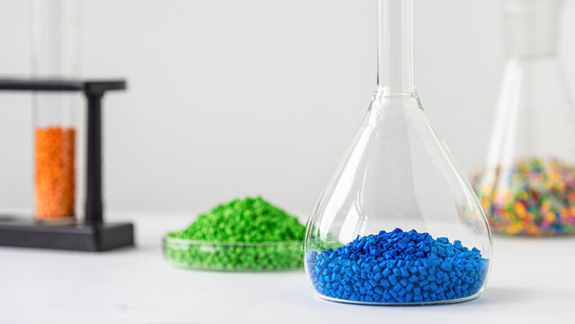 Plastic factory laboratory. Glass flasks with colored dye in granules for plastics. polymer industry.