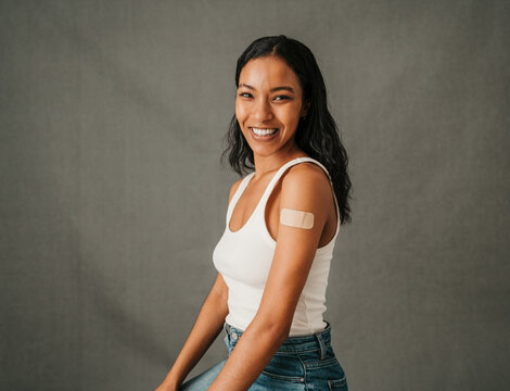 Close up Multiethnic female sitting smiling with a band aid on her arm