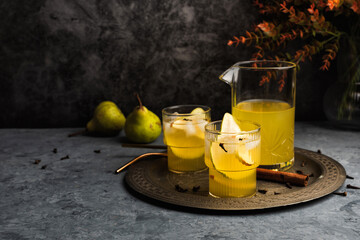 Autumn ice cider cocktail with apple and pear on the gray table. Glass of sangria or punch