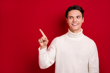 Portrait of good mood smiling handsome brunet hair guy wear white knitwear finger direct empty...