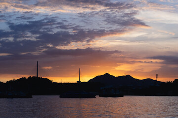 sunset at the sea with mild sun-rays clouds and blue pink orange sky beautiful skyline