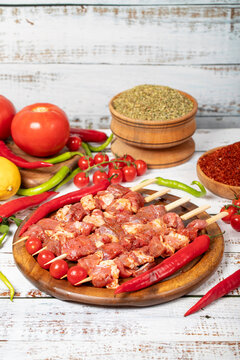 Lamb skewers on wood background. Raw lamb skewer with herbs and spices. Local name kuzu kusleme