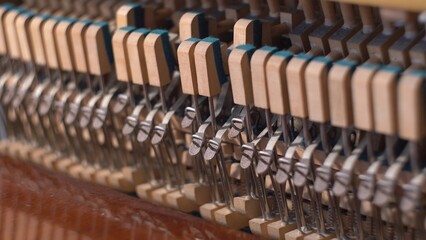 Upright Piano Mechanism Hammers Striking Strings When Song is Played by Musician
