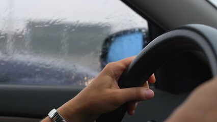 Car Dashboard and Female Hands Holding Steering Wheel When Driving in Heavy Rain