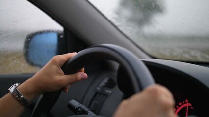 Fototapeta na wymiar Car Dashboard and Female Hands Holding Steering Wheel When Driving in Heavy Rain