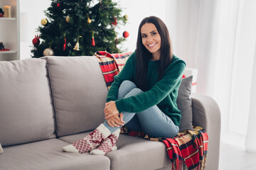 Photo of cheerful positive lady dressed knitted x-mas sitting couch enjoying noel time indoors...
