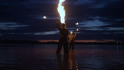 Professional Stuntwoman And Stunt Man Performing Tricks With Fire, Amazing Fire Show On River Coast