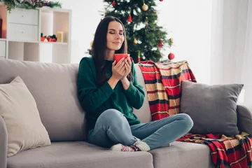 Foto op Plexiglas Full length size photo of cute sitting lotus pose woman wear cozy winter warm outfit relaxing favorite sofa hold mug coffee smell aroma latte indoors © deagreez