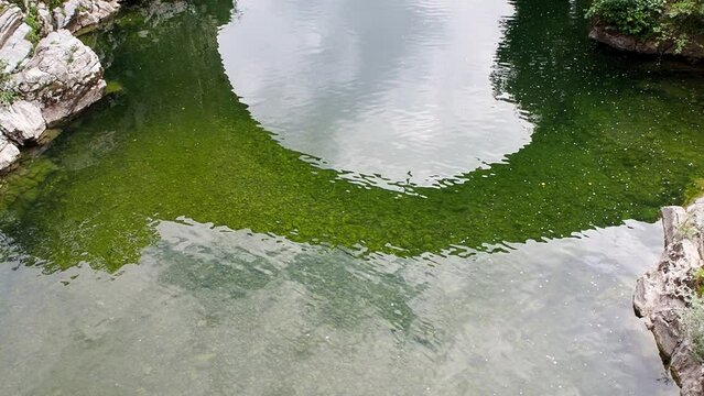 Tilt up Roman bridge, Puente Vieyu or Puenton, historic site in Cangas de Onis, Asturias, Spain. Tourist landmark monument over Sella river. Romanesque style with arches and the Victory Cross hanging.
