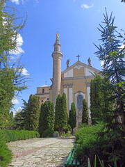 Comfortable courtyard of the Catholic cathedral surrounded by lush evergreen vegetation.