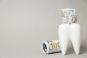 Decorative tooth and money on gray background, space for text