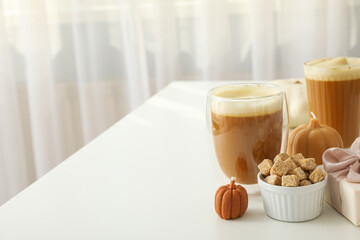 Pumpkin coffee, gift box and candles on white background, space for text