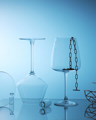 Elegant empty wine glasses, women bracelets, reflection contour minimalistic still life on a blue background.