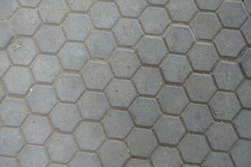 Texture of gray concrete pavement with honeycomb geometric pattern