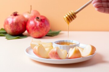 Closeup of plate with apples and honey for Jewish holiday Rosh Hashanah