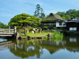 Fototapeta na wymiar Jardin japonais traditionnel à proximité du chateau japonais de Hikone, près de Osaka, au Japon, en été.