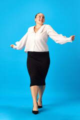 Full length portrait of beautiful smiling plus size woman in stylishly officially outfit dance with...