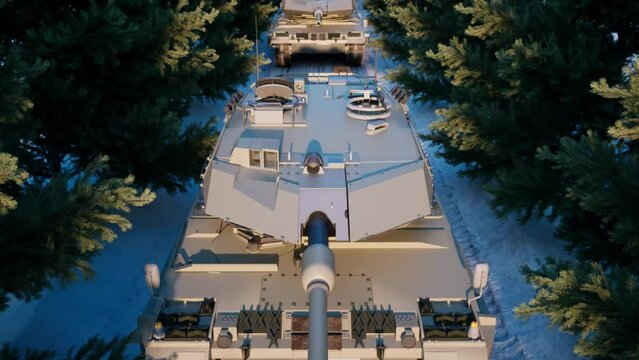 An aerial view over an armored military tank platoon taking cover under the spruce trees of a snow-covered road.