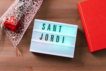  Red rose and red book on wooden background, Sant Jordi holiday card