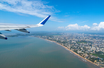 Airplane during take off above Mumbai and sea during warm summer day