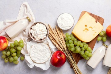 Shavuot flat lay with dairy products, first fruits and wheat