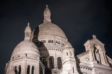 The Basilica of Sacre Coeur de Montmartre illuminated in the evening. Roman Catholic church and minor basilica in Paris dedicated to the Sacred Heart of Jesus. France