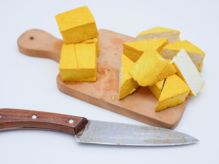 raw yellow tofu on wooden cutting board