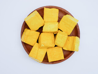 top view of raw yellow tofu on wooden plate