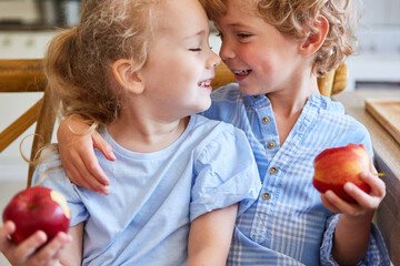 Cute siblings having apples at home