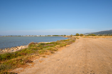 Fototapeta na wymiar Gravel road along Tigaki salt lake (Alykes) on the island of Kos. Greece