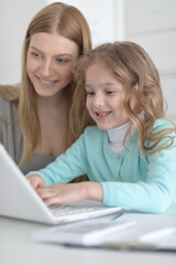 Mother and daughter looking at laptop computer