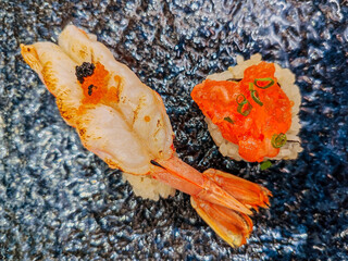 Grilled Shrimp Sushi and Salmon Roe Sushi In a plate. Together, the two sushi contrast in texture and flavor: the tender warmth of shrimp juxtaposed with the cool, popping sensation of roe.