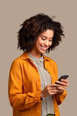 woman of color with curly hair looking at her smartphone with brown background