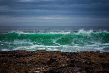 Green wave crashes on the beach