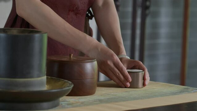 Person covering a jar of tea after preparing the traditional tea-making ceremony.