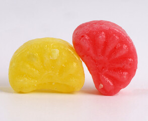 mixed fruit sugar syrup candies on white background, orange candies 