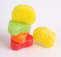 mixed fruit sugar syrup candies on white background, orange candies 
