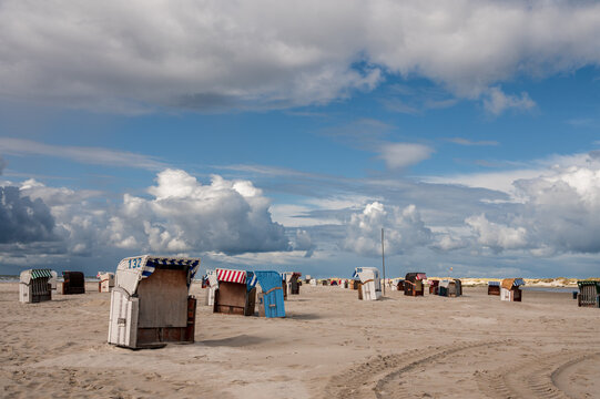 Strandleben am feinen Sandstrand von Norddorf auf der Nordseeinsel Amrum mit dramatischen Wolkenformationen