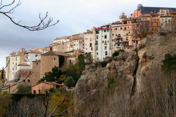 Fototapeta na wymiar Cliffs and a row of colored houses against a stormy sky in the historic part of Cuenca, near Madrid, Spain