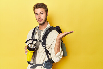 Traveler with mountain backpack and torch showing a copy space on a palm and holding another hand...