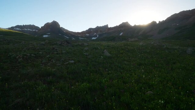 Cinematic pan right wildflower golden hour light Ice Lake Basin Silverton Telluride Ouray Trailhead top of summer snow melted peak sunset in Rocky Mountains valley afternoon dusk stunning landscape
