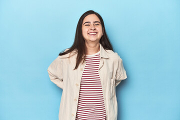 Obraz premium Young Caucasian woman on blue backdrop happy, smiling and cheerful.